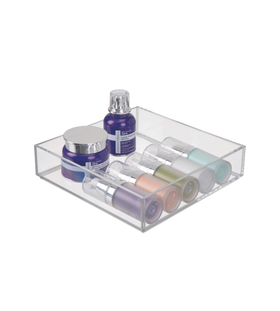Klarer Behälter mit bunten Kosmetikflaschen und -dosen, auf weißer Fläche.