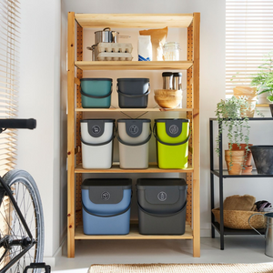 Regaleinheit mit Plastikbehältern, daneben Pflanzen und Fahrrad.