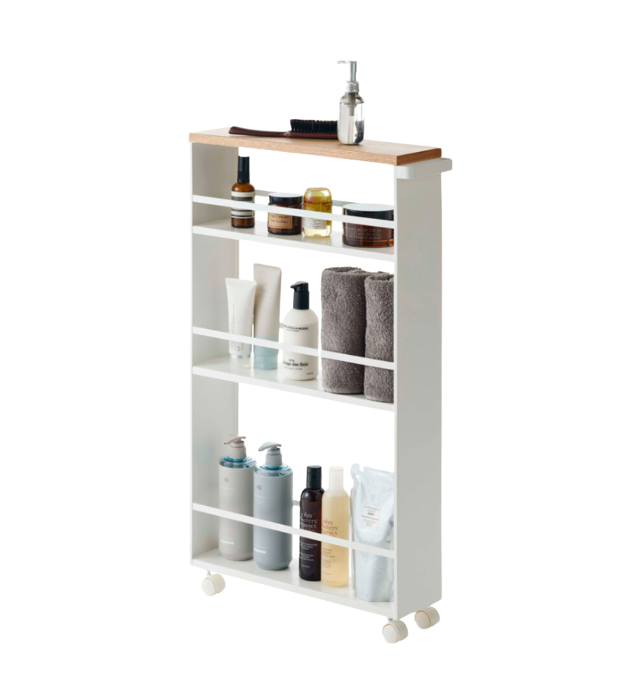 Regal auf Rollen mit Pflegeprodukten und Handtüchern, drei Ebenen mit weißem Rahmen und Holzplatte.