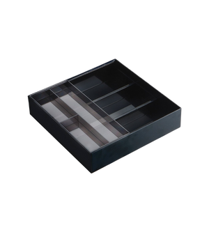 Das YAMAZAKI TOWER Schubladen Organizer Büro in Schwarz ist ein schwarzes, rechteckiges Tablett mit klaren Trennwänden und mehreren Fächern, das leicht schräg auf einem weißen Hintergrund abgebildet ist und so für Ordnung sorgt.