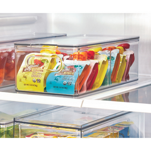 Der iDesign HOME EDIT Aufbewahrungsbehälter KLAR Fridge mit 2 Fächern und Deckel sorgt im Kühlschrank für ordentlich und aufrecht sortierte Bio-Apfelmusbeutel in verschiedenen Farben.